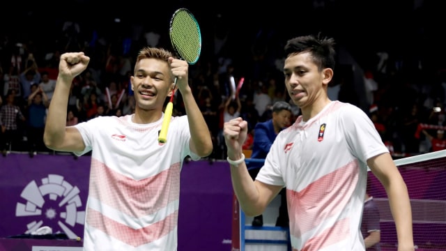Fajar Alfian (kanan) dan Rian Ardianto melakukan selebrasi usai menaklukkan ganda putra Jepang dalam laga semifinal bulu tangkis beregu putra Asian Games 2018. (Foto: ANTARA FOTO/INASGOC/Nafielah Mahmudah)