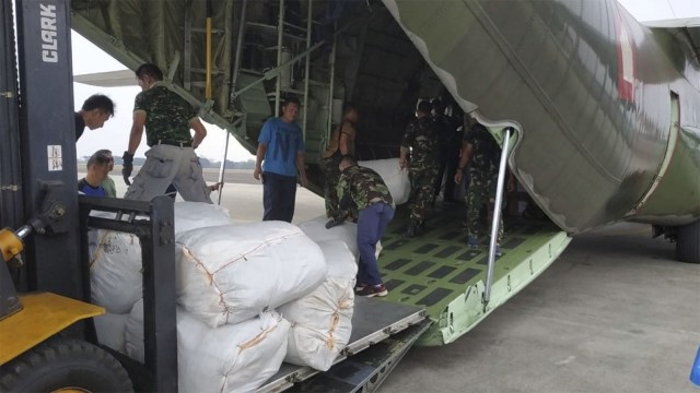 Anggota TNI Angkatan Udara mengangkut daging kurban ke pesawat hercules A-1320 untuk dibagikan kepada korban gempa di Lombok. (Foto: Dok. TNI)