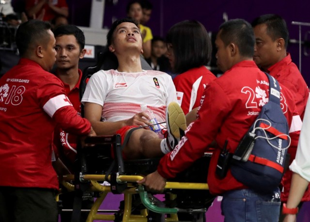 Pebulu tangkis tunggal putra Anthony Sinisuka Ginting (Tengah) cedera saat melawan pebulu tangkis tunggal putra Cina Cina Shi Yuqi, Rabu (22/8). (Foto: ANTARA FOTO/INASGOC/Jessica Margaretha)