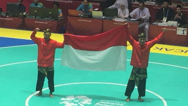 Yola Primadona dan Hendy kibarkan bendera Indonesia di Arena 1 Padepokan Silat TMII, Jakarta.  (Foto: Sandi Firdaus/kumparan)