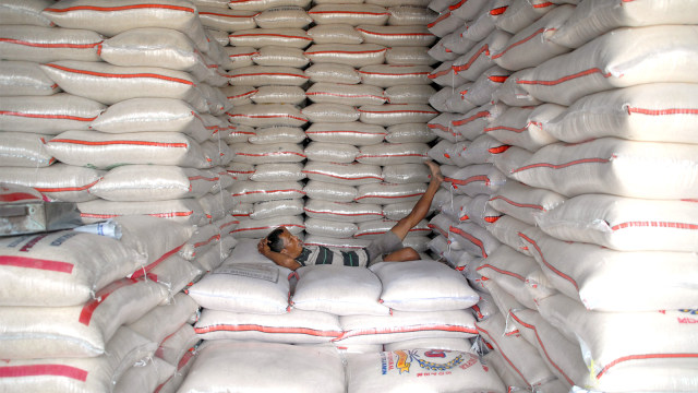 Pekerja tertidur diantara tumpukan karung beras di gudang beras Pasar Induk Beras Cipinang, Jakarta, Kamis (30/82018). (Foto: ANTARAFOTO/Yulius Satria Wijaya)