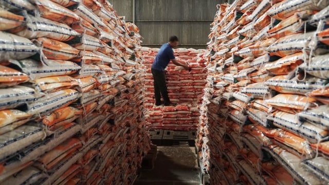 Petugas mengecek susunan beras medium di gedung beras Bulog, Jakarta, Selasa (4/9/2018) (Foto: Jamal Ramadhan/kumparan)