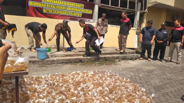 Jajaran Polda DIY memusnahkan 1.150 plastik minuman beralkohol (minol) oplosan atau yang biasa disebut langsung pening disingkat lapen, di Mapolda DIY, Yogyakarta, Selasa (04/09/2018). (Foto: Arfiansyah Panji Purnandaru /kumparan)