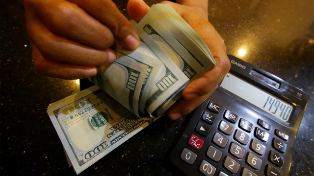 Petugas memperlihatkan uang pecahan dolar Amerika Serikat di gerai penukaran mata uang asing di Jakarta, Selasa (4/9). (Foto: ANTARA FOTO/Rivan Awal Lingga)