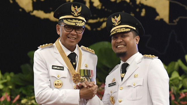Gubernur Nurdin Abdullah (kiri) bersama Wakil Gubernur Sudirman Sulaiman melakukan salam komando usai pelantikan di Istana Negara, Jakarta. Foto: ANTARA FOTO/Puspa Perwitasari