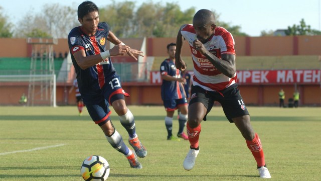Pesepak bola Madura United (MU) FC Greg Nwokolo (kanan) berusaha melewati pesepak bola Selangor FA Mohd Razman B Roslan (kiri) dalam uji tanding di Stadion Gelora Ratu Pamelingan (SGRP) Pamekasan, Jawa Timur, Selasa (4/9). MU memenangi pertandingan tersebut dengan skor 4-1. (Foto: ANTARA/Saiful Bahri)