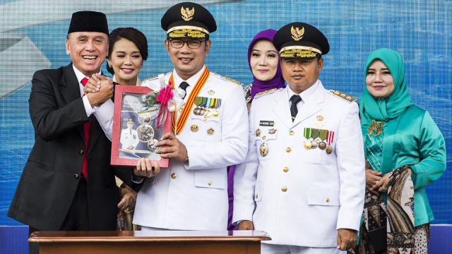 Gubernur Jawa Barat Ridwan Kamil didampingi Wakil Gubernur UU Ruzhanul Ulum menerima buku laporan dari Penjabat Gubernur Jabar M Iriawan saat acara Sertijab Gubernur Jawa Barat di Gedung Sate, Bandung, Jawa Barat, Kamis (6/9).  (Foto: ANTARA FOTO/M Agung Rajasa)