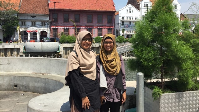 Azizah (Kiri) dan Nopi, turis lokal dari Tasikmalaya berkunjung ke Kali Besar, Selasa (11/9/2018). (Foto: Darin Atiandina)