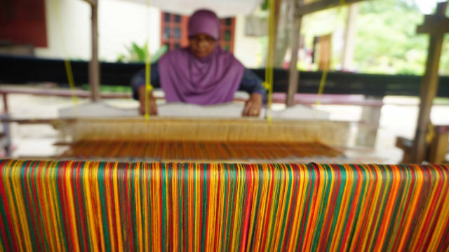 Pengrajin tenun songket Aceh, Jasmani Daud, sedang merajin tenun di tempat usahanya di Jalan Lambaro Angan, Desa Mireuk Taman, Kecamatan Darussalam,  Aceh Besar, Rabu (12/9/2018). (Foto: Zuhri Noviandi/kumparan)