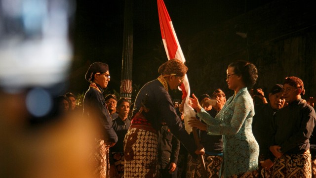 Putri Sultan HB X GKR Mangkubumi secara simbolis menyerahkan bendera merah putih saat tradisi Lampah Budaya Mubeng Beteng di Keraton Yogyakarta. Foto: ANTARA FOTO/Hendra Nurdiyansyah
