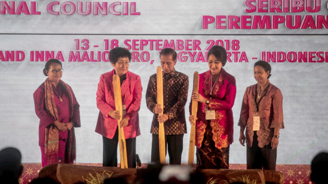 Presiden RI Joko Widodo (tengah) memukul lesung saat pembukaan Sidang Umum International Council of Women di Yogyakarta, Jumat (14/9/2018).  (Foto: ANTARA FOTO/Andreas Fitri Atmoko)
