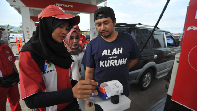 Operator membantu pengendara menggunakan kartu transaksi non tunai, untuk pembelian Bahan Bakar Minyak (BBM). Foto: ANTARA FOTO/Iggoy el Fitra