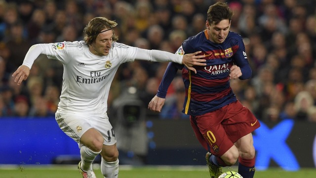 Duel antara Lionel Messi dan Luka Modric. (Foto: Lluis Gene/AFP)