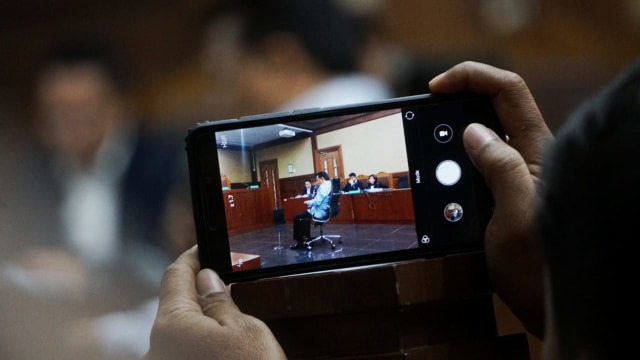 Audiens memotret suasana sidang korupsi. Foto: Jamal Ramadhan/kumparan