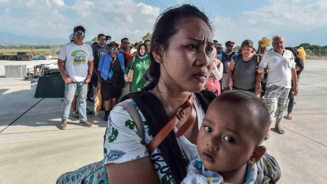 Warga terdampak gempa dan tsunami menunggu masuk ke dalam pesawat untuk dievakuasi di Palu, Sulawesi Tengah, Sabtu (29/9). (Foto: Antara/Muhammad Adimaja)