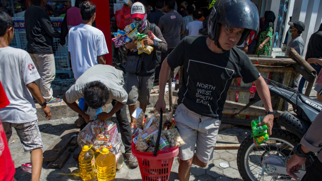 Warga menjarah toko swalayan di Palu, Sulawesi Tengah, pada 30 September 2018. (Foto: AFP/ BAY ISMOYO)