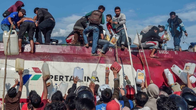 Warga mengambil BBM dari mobil tangki di SPBU, Palu, Sulawesi Tengah, Minggu (30/9). Gempa dan tsunami yang melanda wilayah Palu mengakibatkan kesulitan BBM. (Foto: ANTARA FOTO/Muhammad Adimaja)