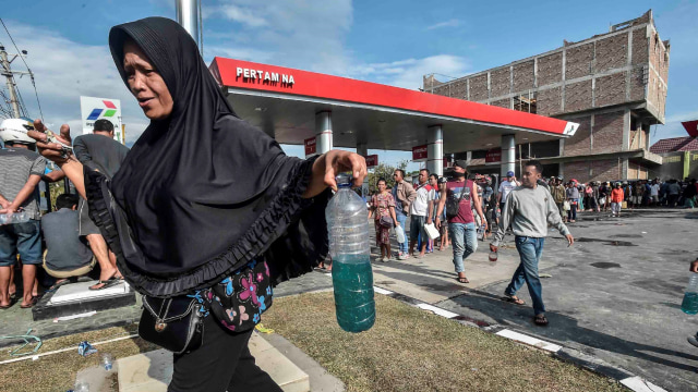 Warga membawa BBM di SPBU, Palu, Sulawesi Tengah, Minggu (30/9). Gempa dan tsunami yang melanda wilayah Palu mengakibatkan kesulitan BBM. (Foto: ANTARA FOTO/Muhammad Adimaja)