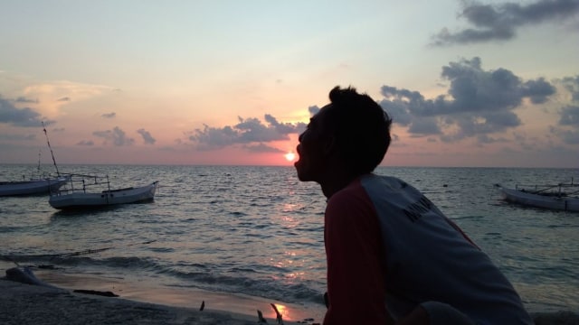 Mardijo pekerja di Palu saat bermain dipinggir pantai. (Foto: Dok. Mardijo)