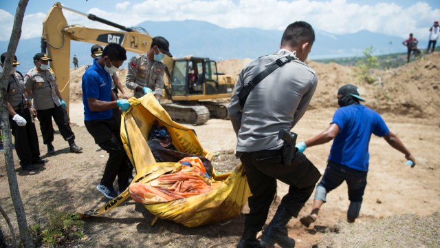 Proses pemakaman masal jenazah korban gempa dan tsunami di Palu, Sulawesi Tengah. (Foto: AFP/BAY ISMOYO)
