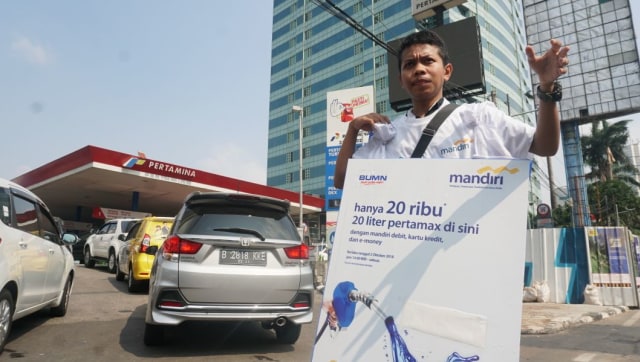 Petugas memberikan info mengenai promo pembelian BBM jenis Pertamax di SPBU Jalan HR Rasuna Said. (Foto: Nugroho Sejati/kumparan)