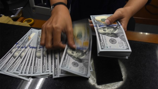 Petugas kasir menghitung mata uang dolar Amerika Serikat (AS) di tempat penukaran uang di kawasan Kwitang. Foto: ANTARA FOTO/Indrianto Eko Suwarso