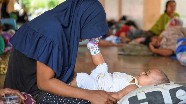 Seorang ibu bermain dengan anaknya di tenda pengungsian di Lapangan Vatulemo, Palu, Sulawesi Tengah, Selasa (2/10). (Foto: ANTARA FOTO/Hafidz Mubarak A)