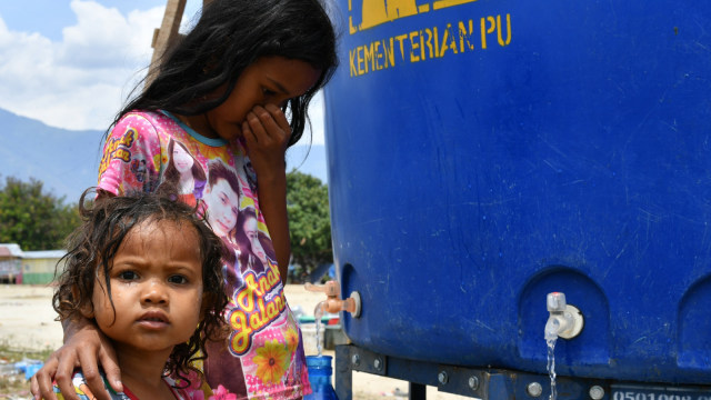 Anak-anak mengambil air bersih di pengungsian sementara di Palu. (Foto: AFP/ADEK BERRY)