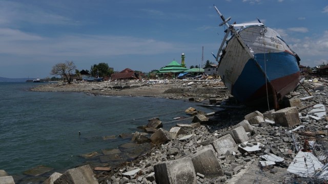 Warga melintas di kawasan Pel. Wani yang dihantam gempa dan tsunami, Kab. Donggala. (Foto: Jamal Ramadhan/kumparan)
