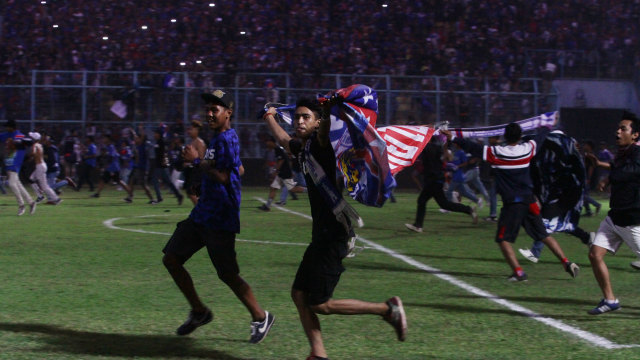 Oknum suporter Arema FC memasuki lapangan usai tim kesayangannya mengalahkan Persebaya Surabaya di Stadion Kanjuruhan, Malang, Jawa Timur, Sabtu (6/10) Dalam pertandingan tersebut Arema FC mengalahkan Persebaya dengan skor akhir 1-0. (Foto: ANTARA FOTO/Ari Bowo Sucipto)