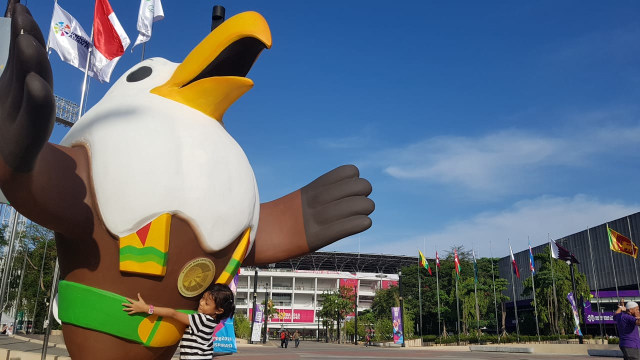 Seorang anak memeluk patung Momo maskot Asian Para Games 2018
 (Foto: Prameshwari Sugiri/kumparan)