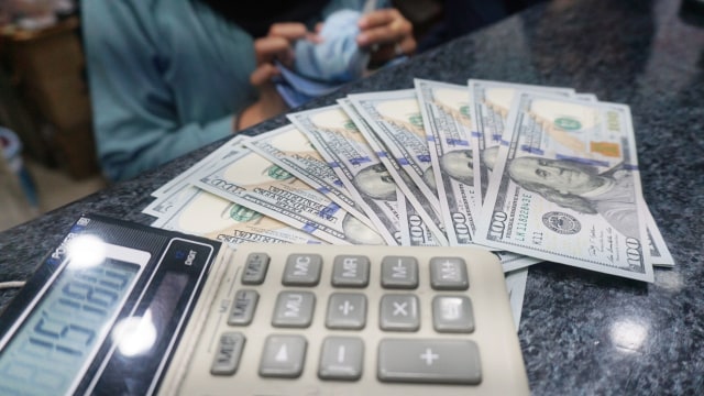 Petugas memperlihatkan pecahan uang dolar dan rupiah di salah satu tempat penukaran mata uang asing/money changer di Jakarta. (Foto: Fanny Kusumawardhani/kumparan)