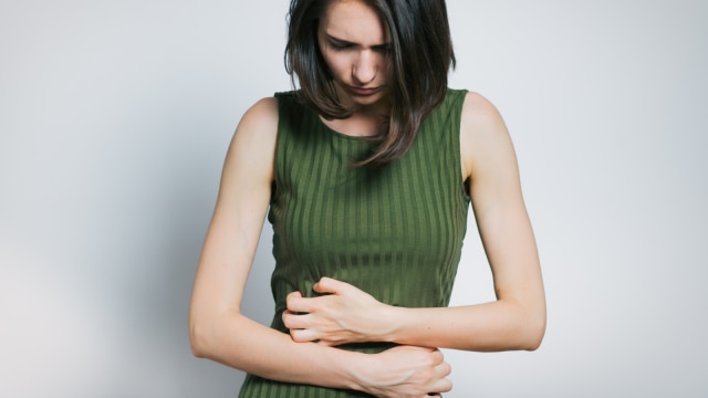 Ilustrasi seorang perempuan sedang mengalami perut kembung usai minum susu sapi. Foto: Shutterstock