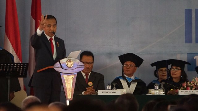 Presiden Joko Widodo memberikan orasi ilmiah pada sidang terbuka senat Universitas Kristen Indonesia di Kampus UKI, Jakarta, Senin (15/10). (Foto: Fanny Kusumawardhani/kumparan)