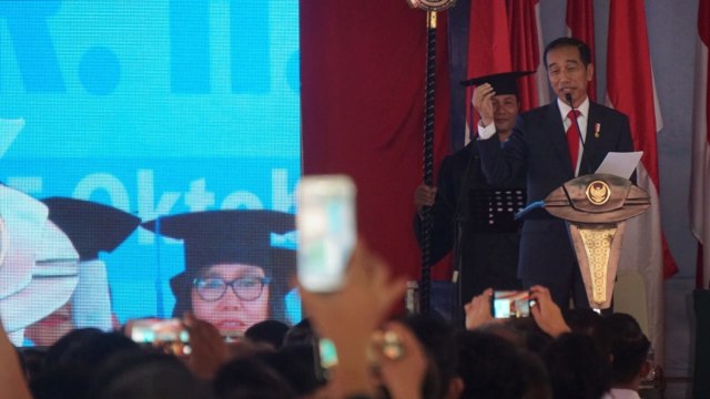 Presiden Joko Widodo memberikan orasi ilmiah pada sidang terbuka senat Universitas Kristen Indonesia di Kampus UKI, Jakarta, Senin (15/10). (Foto: Fanny Kusumawardhani/kumparan)
