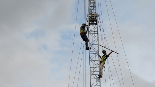 Pekerja memperbaiki Base Tranceiver Station (BTS) milik Telkomsel yang terdampak gempa bumi di Palu Foto: ANTARA FOTO/Basri Marzuki