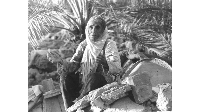 Seorang wanita tua di antara reruntuhan bangunan pascagempa tahun 1978 di Kota Tabas, Iran. (Foto: Wikimedia commons)