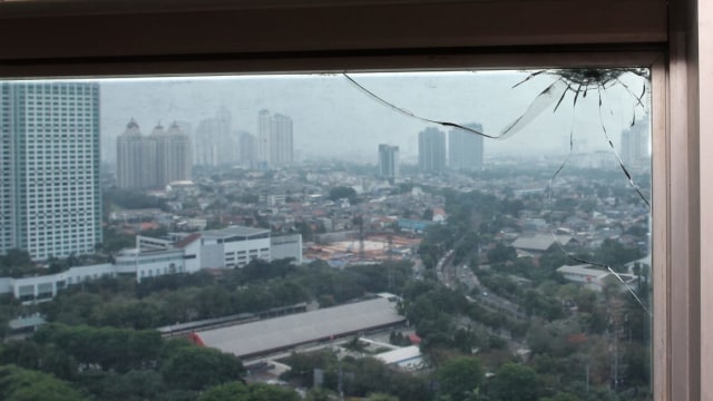 Retakan kaca jendela di lantai 20 ruang 20.03 milik anggota Fraksi PAN Totok Daryanto diduga dari peluru nyasar dari lapangan tembak. (Foto: Helmi Afandi Abdullah/kumparan)