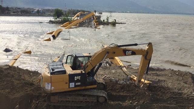 Alat berat sedang mengangkut bagian reruntuhan jembatan kuning, Palu, Rabu (24/10/2018).  (Foto: Adhi Muhammad Daryono/kumparan)