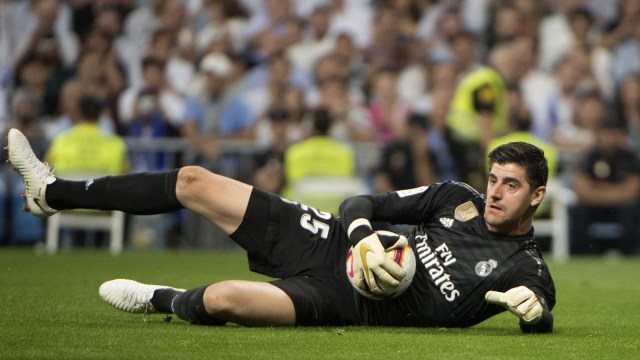 Thibaut Courtois melakukan penyelamatan dalamm laga Real Madrid vs Atletico Madrid. (Foto: Curto De La Torre/AFP)