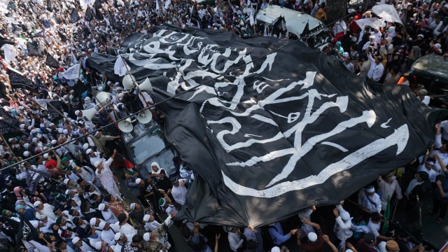 Massa yang tergabung dalam Barisan Nusantara Pembela Tauhid membawa bendera bertuliskan kalimat tauhid di Jalan Medan Merdeka Barat, Jakarta Pusat, Jumat (26/10/2018). (Foto: Jamal Ramadhan/kumparan)