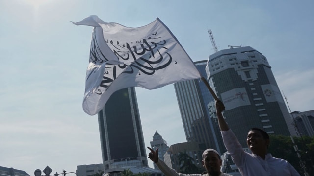 Massa yang tergabung dalam Barisan Nusantara Pembela Tauhid membawa bendera bertuliskan kalimat tauhid di Jalan Medan Merdeka Barat, Jakarta Pusat, Jumat (26/10/2018). (Foto: Jamal Ramadhan/kumparan)