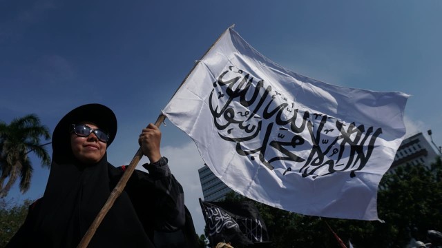 Massa yang tergabung dalam Barisan Nusantara Pembela Tauhid membawa bendera bertuliskan kalimat tauhid di Jalan Medan Merdeka Barat, Jakarta Pusat, Jumat (26/10/2018). (Foto: Jamal Ramadhan/kumparan)