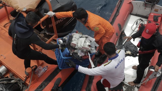 Sejumlah anggota Basarnas membawa puing-puing pecahan pesawat Lion Air JT-610 dan jenazah korban ke dalam kapal induk Basarnas di perairan Tanjung Pakis, Karawang, Selasa (30/10). (Foto: Aditia Noviansyah/kumparan)