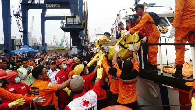 Petugas menurunkan kantong jenazah yang berisi serpihan pesawat Lion Air JT-610 di Dermaga JICT, Selasa (30/10/2018). (Foto: Irfan Adi Saputra/kumparan)