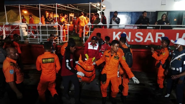 Tim SAR turunkan kantong jenazah dari kapal KN SAR Basudewa (Foto: Irfan Adi Saputra/kumparan)