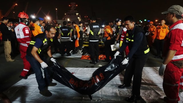 Tim SAR turunkan kantong jenazah dari kapal KN SAR Basudewa (Foto: Irfan Adi Saputra/kumparan)