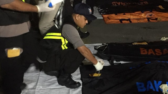 Tim SAR turunkan kantong jenazah dari kapal KN SAR Basudewa (Foto: Fachrul Irwinsyah/kumparan)