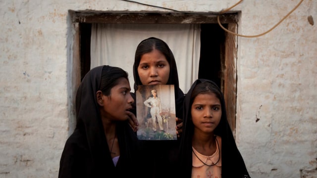 Putri Asia Bibi memegang foto ibunya. (Foto: REUTERS/Adrees Latif)