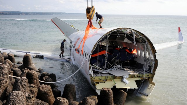 Pesawat Lion Air terperosok ke laut di sisi barat landas pacu Bandara Ngurah Rai, Bali, 13 April 2013. (Foto: Sonny Tumbelaka/AFP)